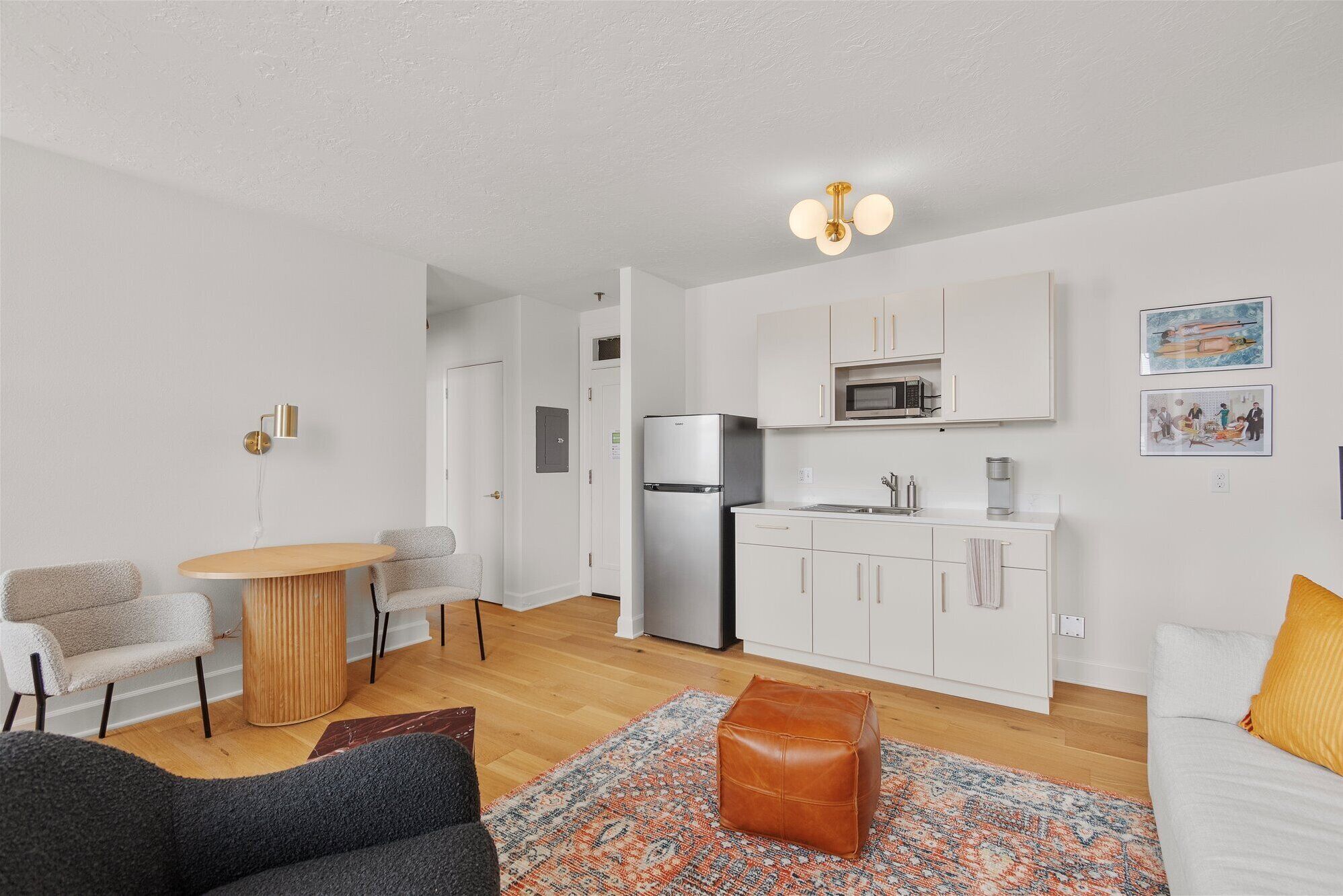 A compact living space with a kitchenette, a dining area, and a seating area.