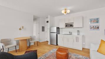 A compact living space with a kitchenette, a dining area, and a seating area.