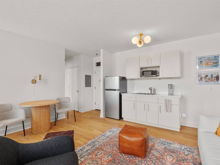 A compact living space with a kitchenette, a dining area, and a seating area.