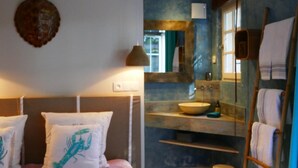 Un baño con un espejo grande, un lavabo y un perchero para toallas.