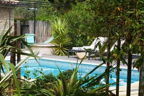 A swimming pool with lounge chairs and a pergola. - La Vagabonde (Saint-Tropez)