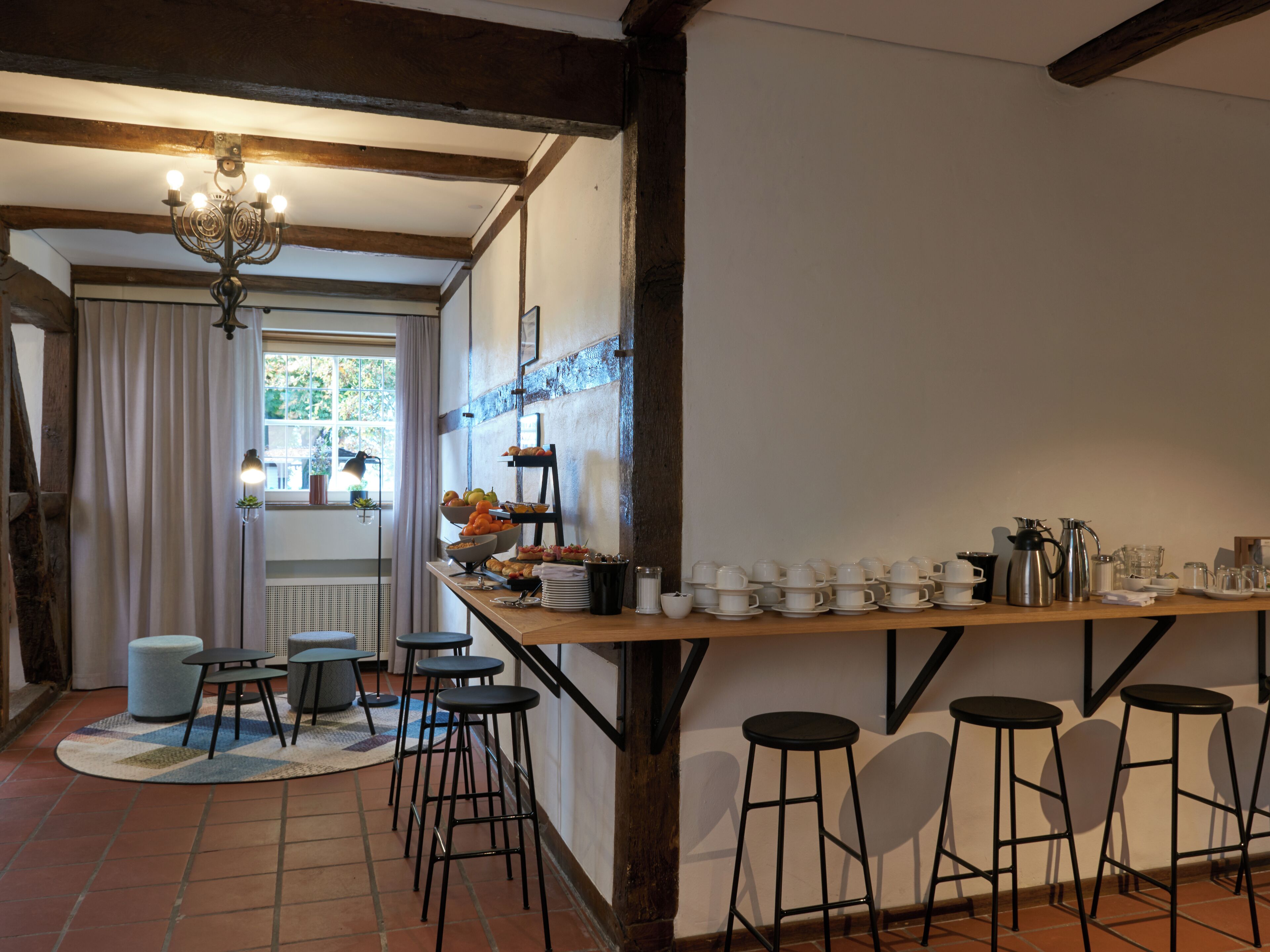 Une cuisine équipée d’un bar en bois, de tabourets et proposant une variété d’aliments pour le petit-déjeuner.