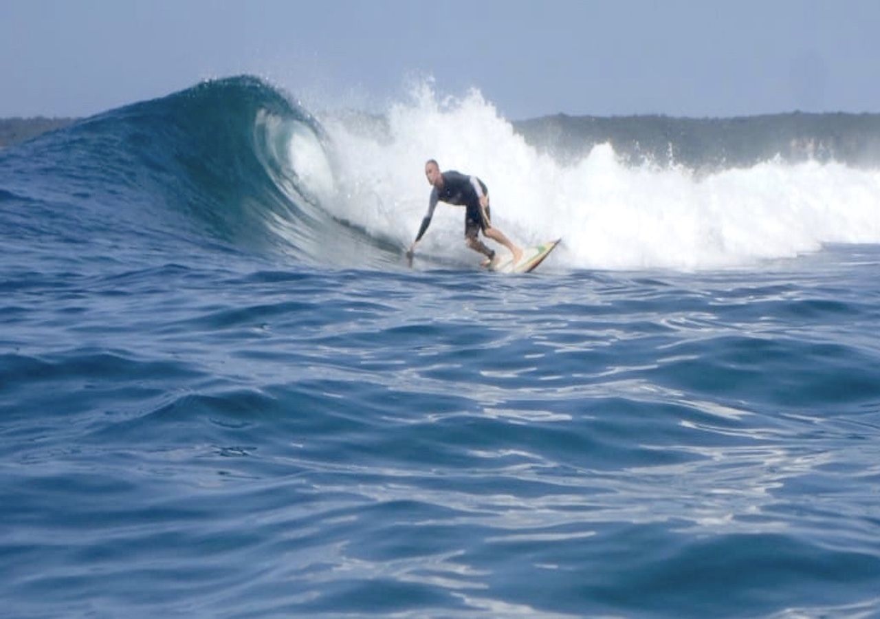Una persona surfeando una ola en el océano.