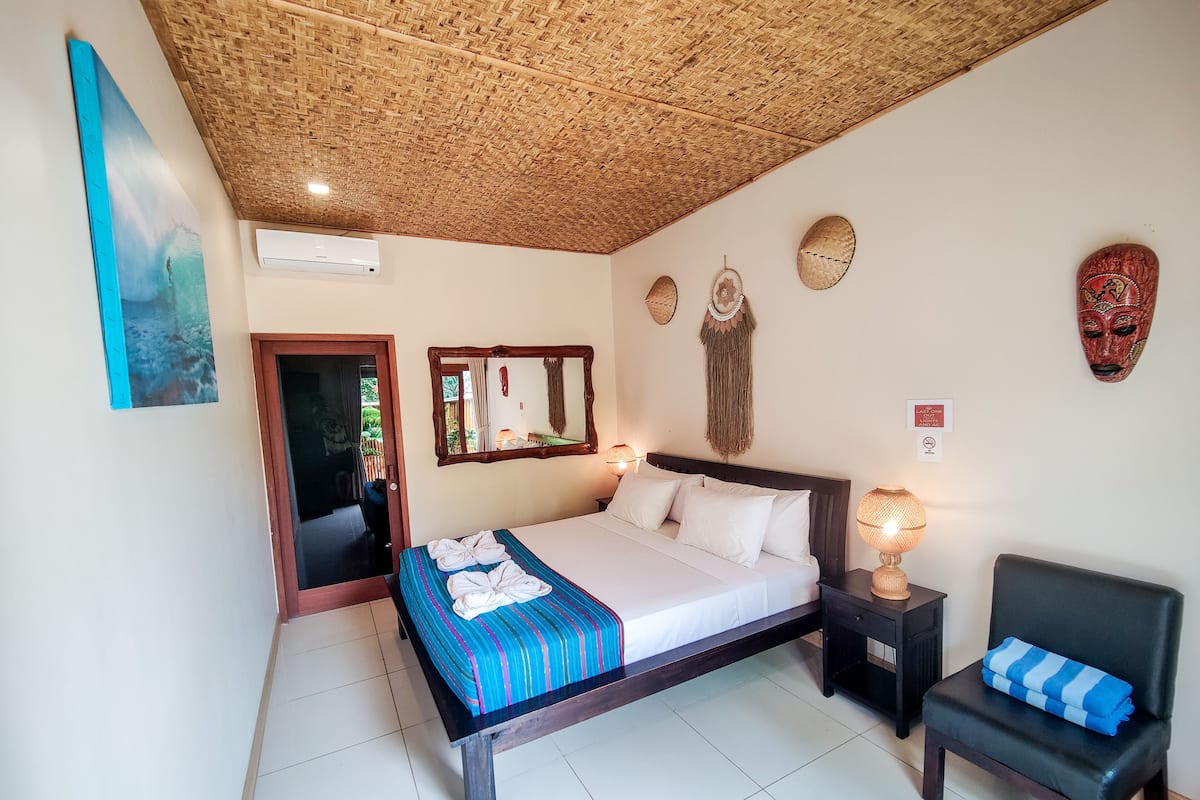 Une chambre à coucher avec un lit, une chaise, un miroir et des éléments décoratifs sur les murs.