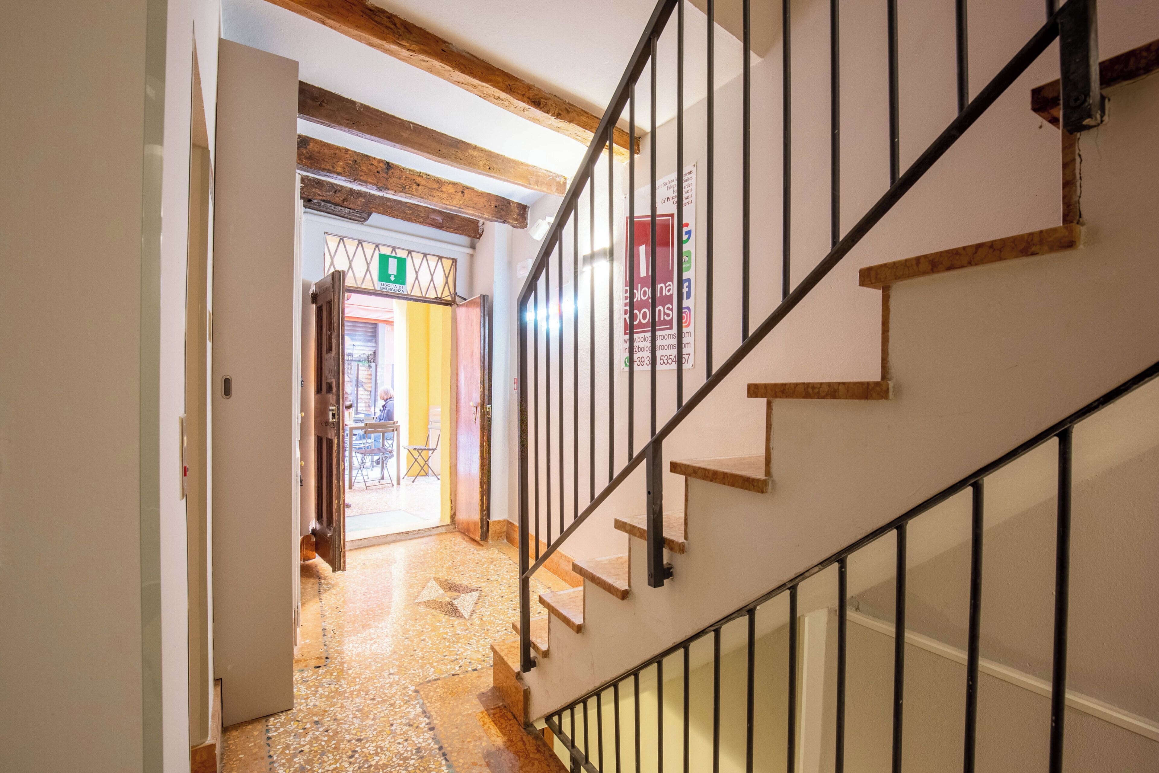 A staircase with wooden steps and metal railings leading to a room with a tiled floor.