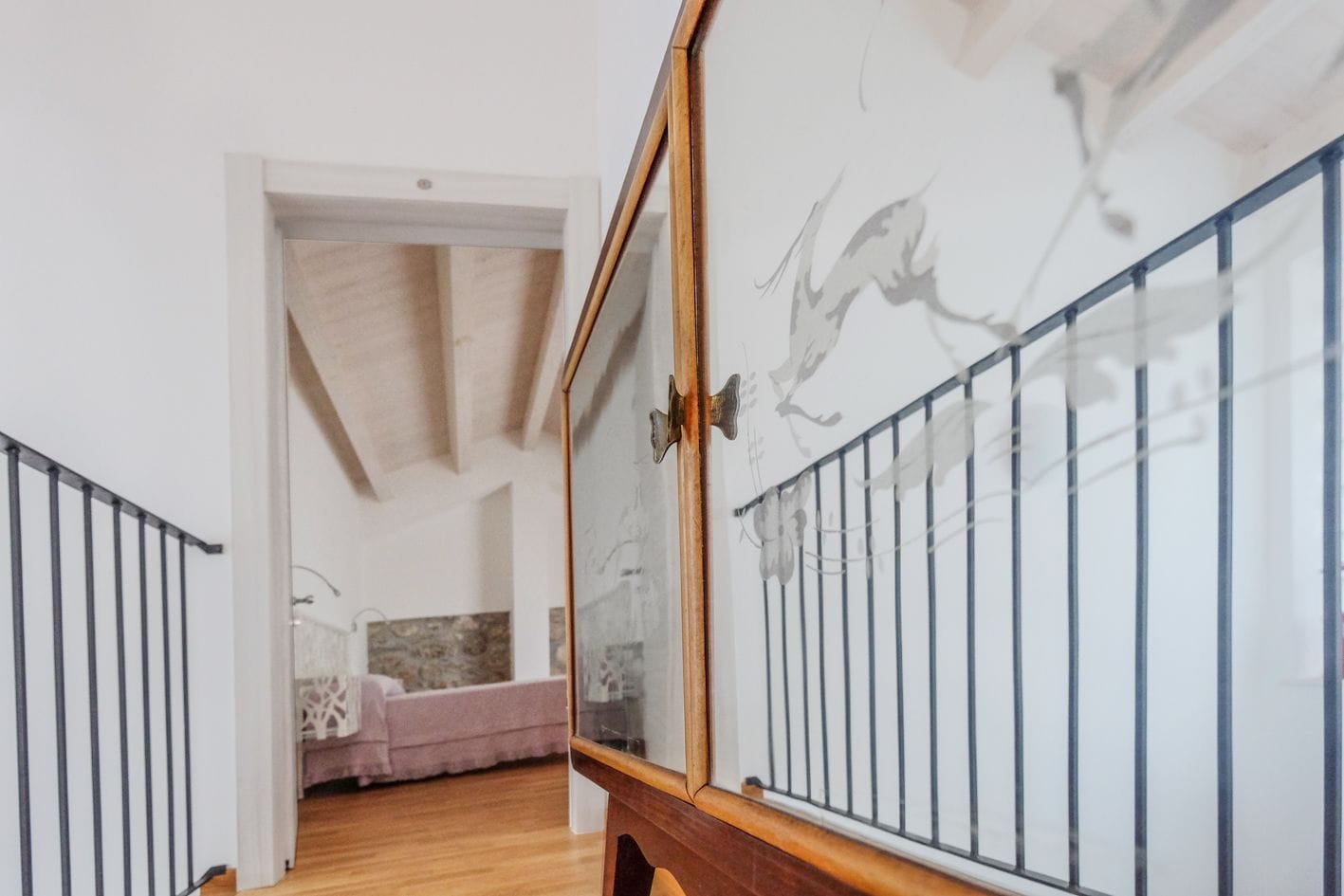 Una escalera conduce a un dormitorio con una cama y una mesita de noche.