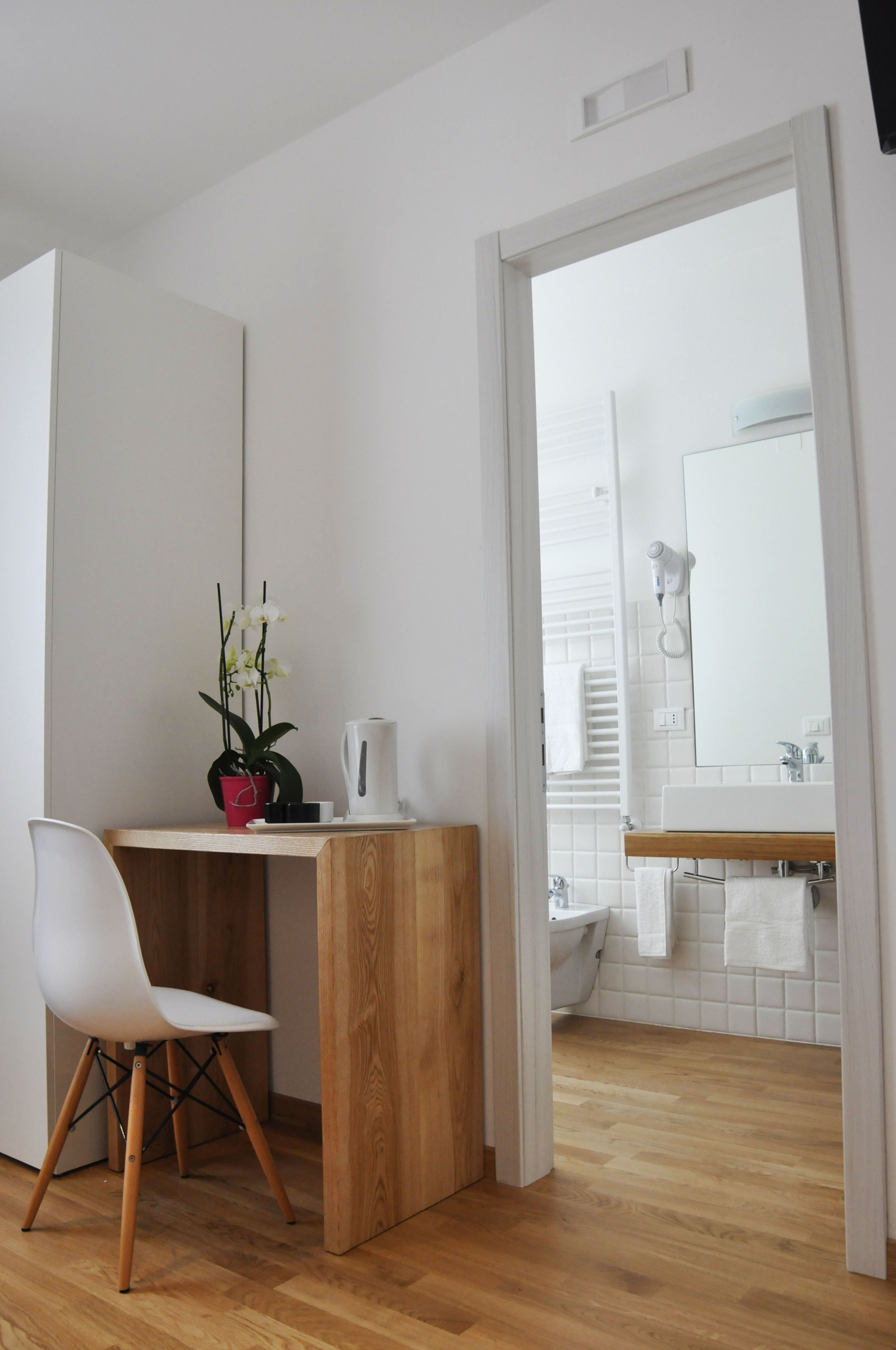 A modern bathroom with a wooden vanity, white sink, and a white toilet.