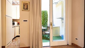 A hallway with a sliding glass door leading to a patio with a table and chairs.