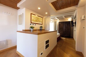 A modern kitchen with a wooden countertop, a built-in oven, and a window with curtains.