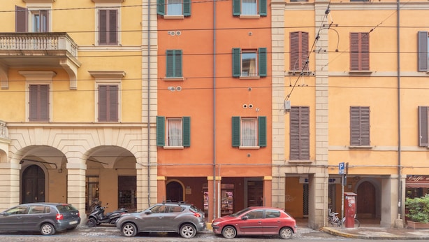A row of colorful buildings with arched doorways and shutters.