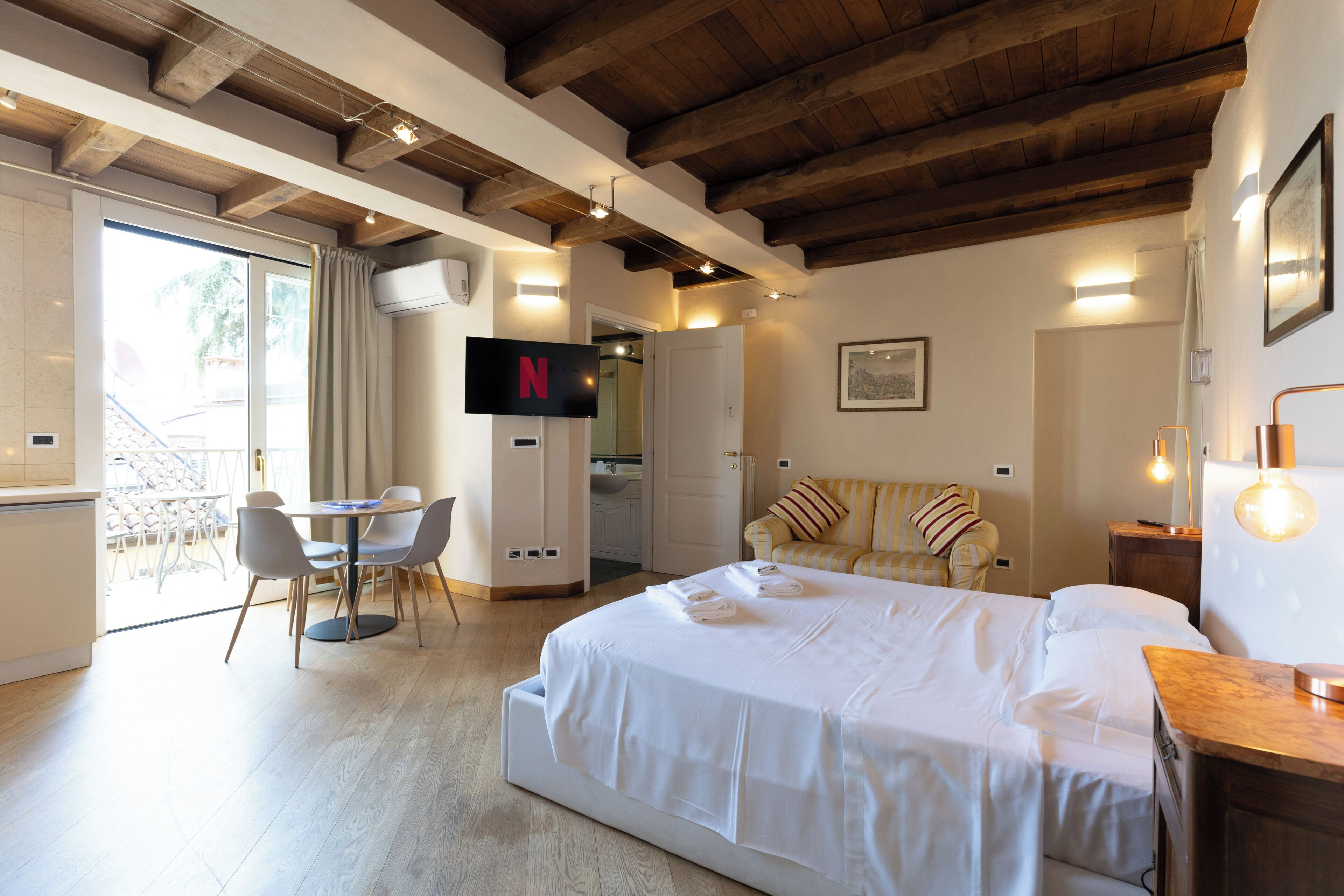 Une chambre d’hôtel équipée d’un lit, d’un bureau, d’une chaise, d’une télévision et d’un canapé.