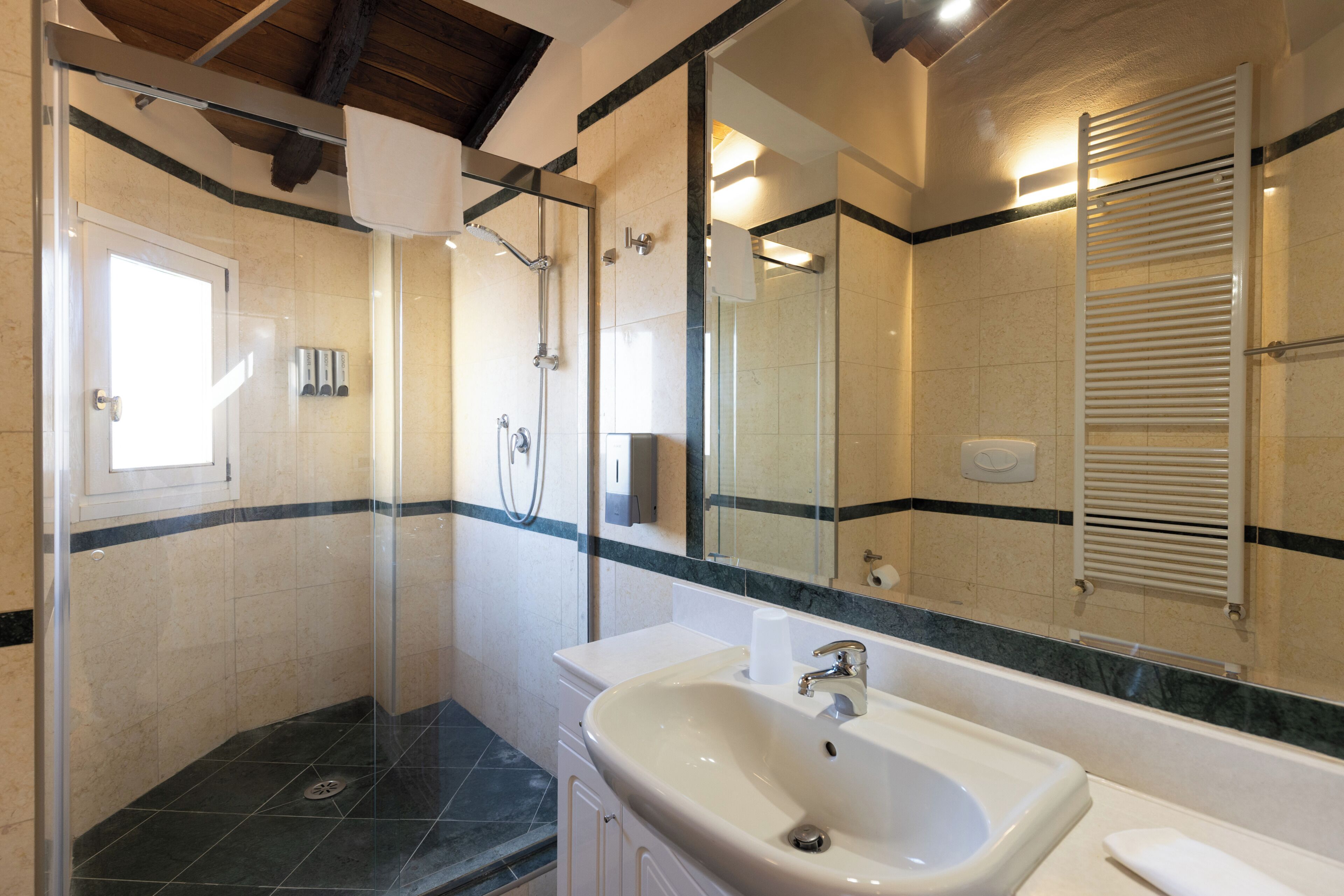 Un baño con ducha, lavabo y espejo.