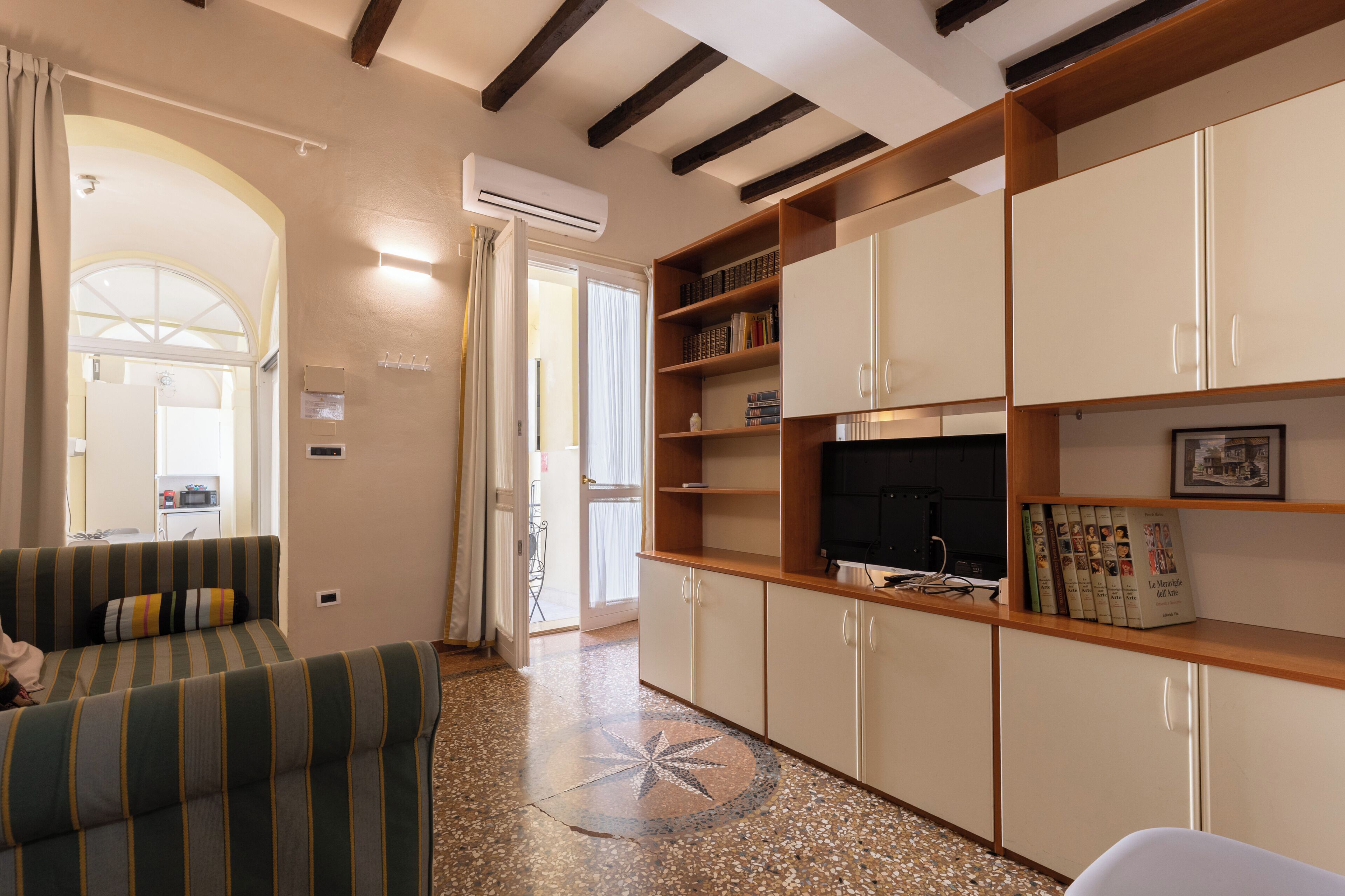 A living room with a sofa, a television, and a bookshelf.