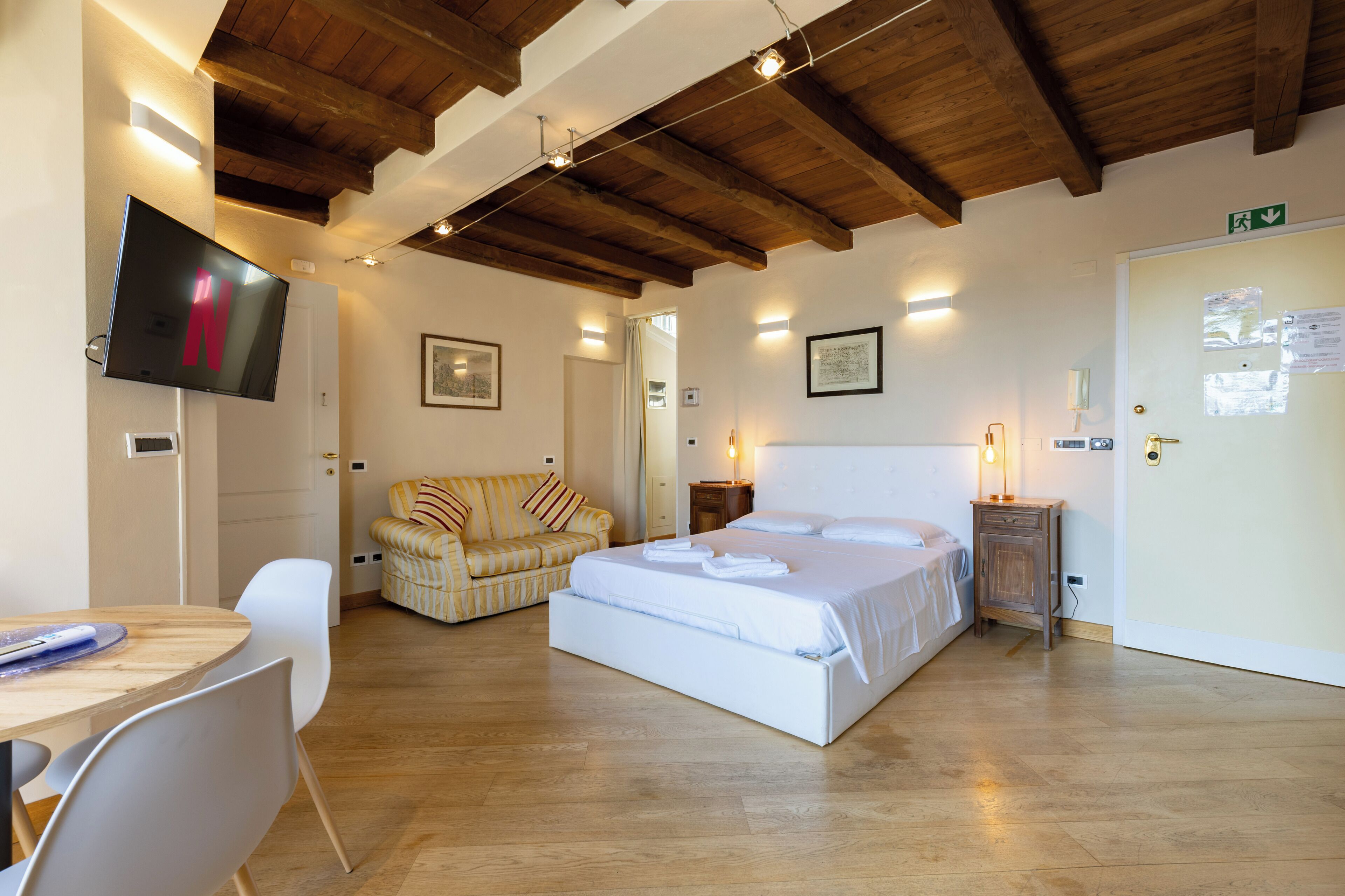 Une chambre d’hôtel avec un lit, un canapé, une télévision et un bureau.
