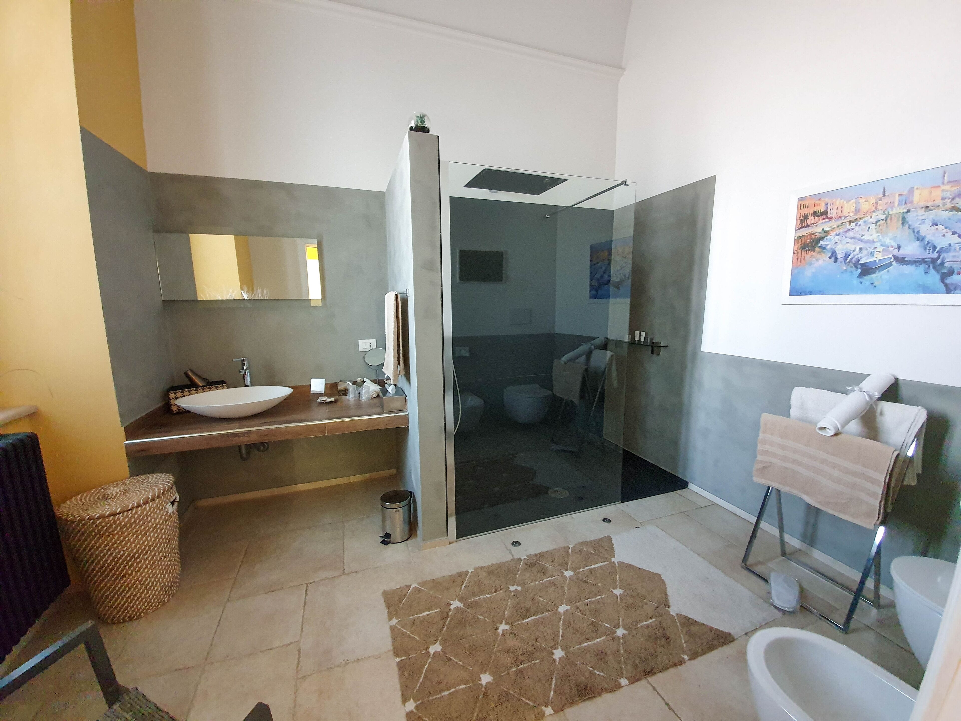 Une salle de bain moderne avec un grand lavabo, une douche à parois de verre et des toilettes.