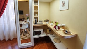 A compact living space with a mirrored wardrobe, a small dining area, and a kitchenette. - Turenum Apartment B&B (Trani)