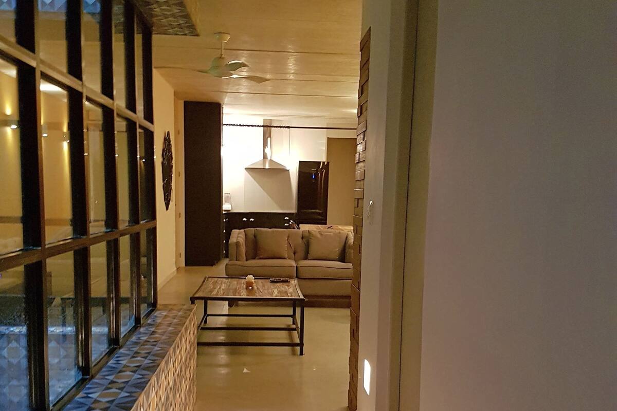A hallway with a patterned floor, a sofa, and a coffee table.