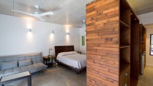 Une chambre moderne avec un mur d’accent en bois, un lit, un canapé et un bureau.