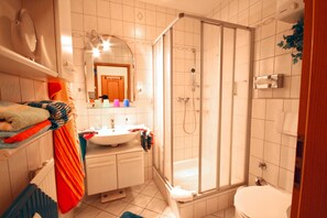 A bathroom with a shower, sink, and toilet. - Residenz Albatros (Cuxhaven)