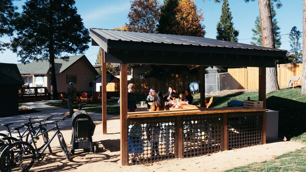 A small outdoor market stall with a metal roof, surrounded by a wooden fence. - Summit View Inn (Mount Shasta)