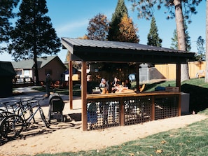 A small outdoor market stall with a metal roof, surrounded by a wooden fence. - Summit View Inn (Mount Shasta)
