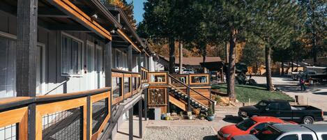 A building with a wooden deck and a staircase leading to a covered area.