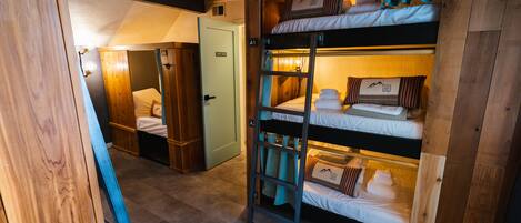 A bunk bed room with a ladder, wooden walls, and a door labeled "A1".
