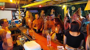 En välbesökt bar med trämöbler och en rustik inredning.
