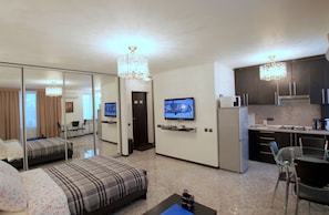 Enjoy a comfortable stay in this stylish room featuring a large bed, flat-screen TV, kitchenette, and dining area.