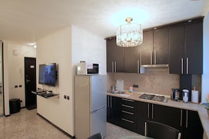 Enjoy cooking in this well-equipped kitchen with a flat-screen TV, microwave, and gas stove.