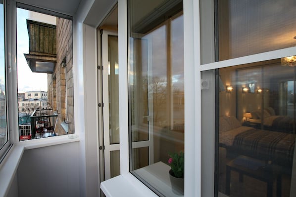 Enjoy the city view from your balcony with a small table and potted plant.
