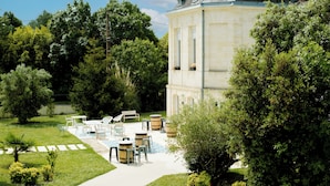 Ein Gebäude mit Garten und einer Terrasse, die Gartenmöbel und einen Weg zeigt.