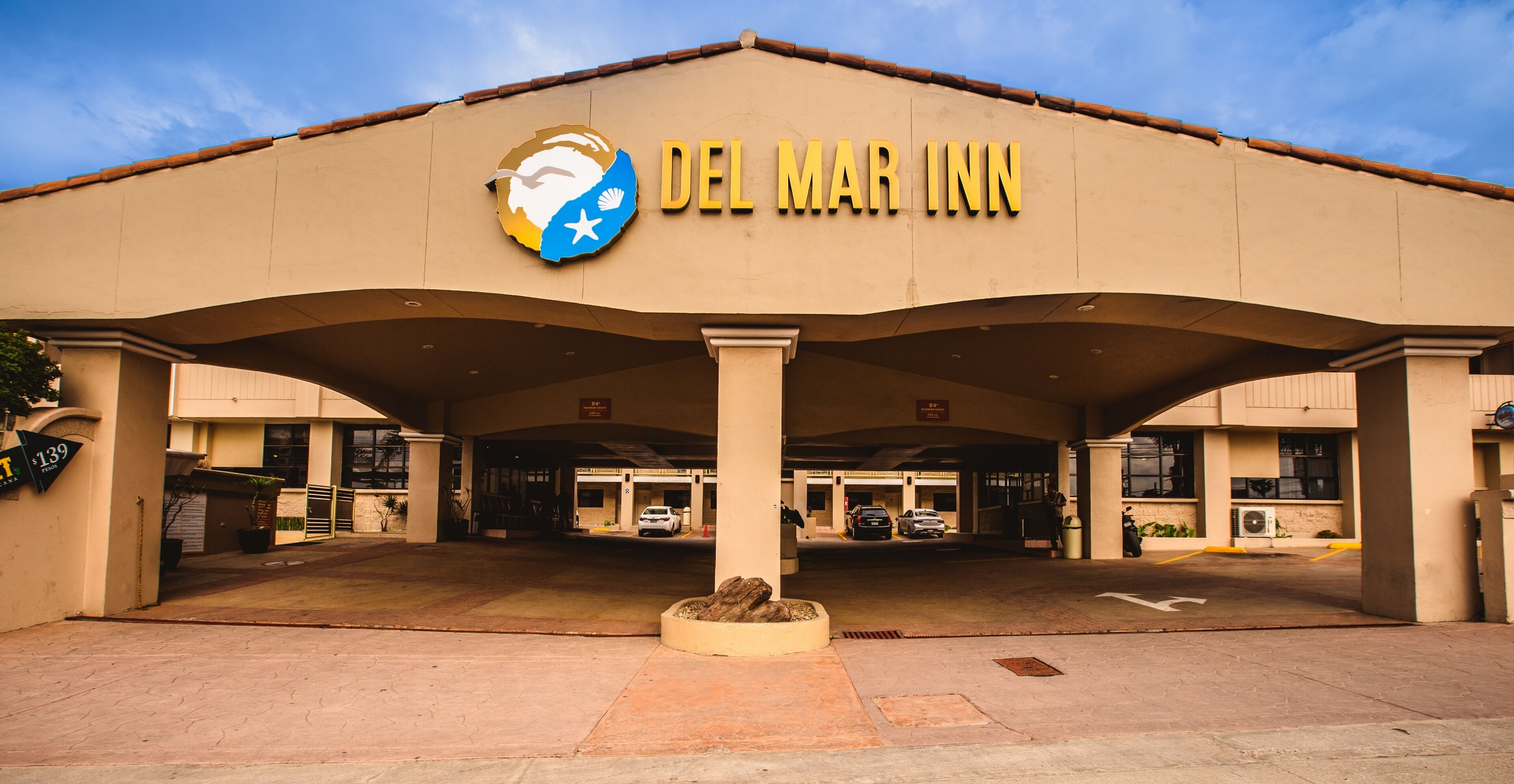 Vue dégagée de l’extérieur du Del Mar Inn, montrant l’entrée et le parking.