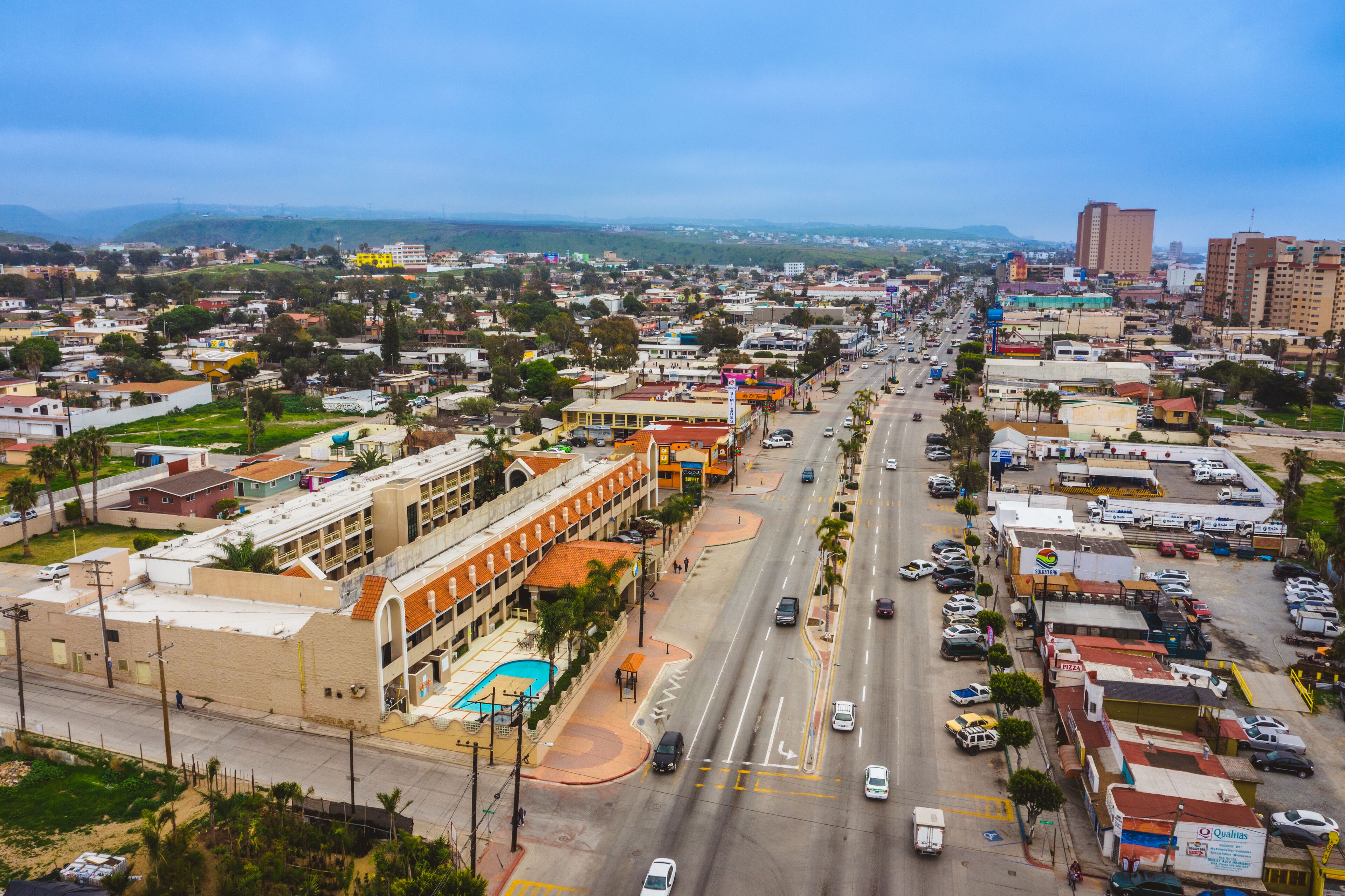 A cityscape with a wide street, buildings, and vehicles.
