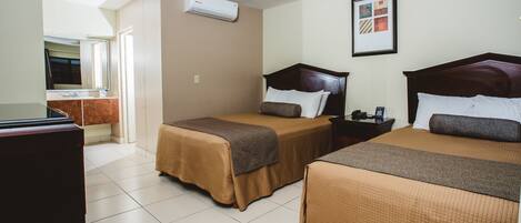 A hotel room with two beds, a TV, and an air conditioning unit.