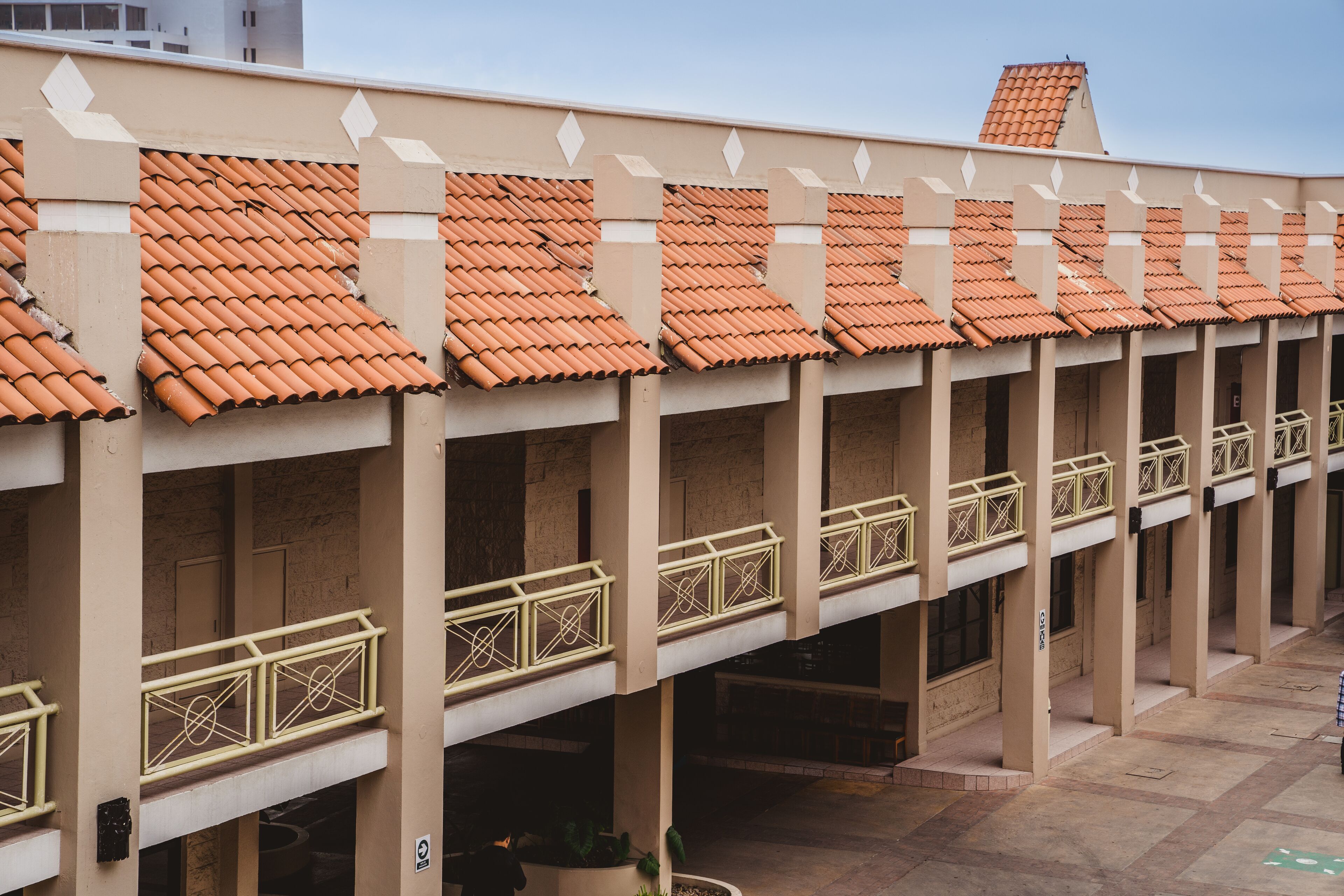 Un edificio con techo de tejas, varios balcones con barandillas y un patio interior.