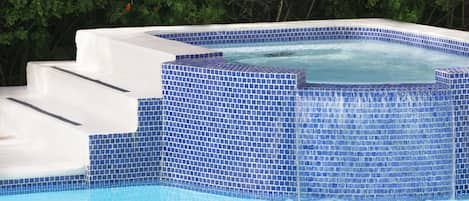 Alberca al aire libre, sombrillas en la alberca y camastros