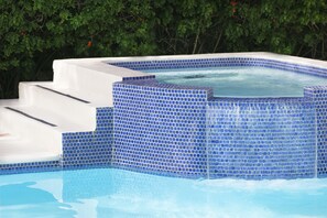 Alberca al aire libre, sombrillas en la alberca y camastros 