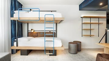 Ein Stockbett mit einer Leiter, ein Nachttisch mit Lampe sowie ein an der Wand befestigtes Regal.