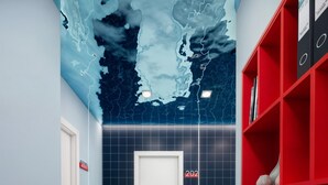 Un couloir avec une porte portant le numéro 202, une bibliothèque rouge et un coussin à rayures.
