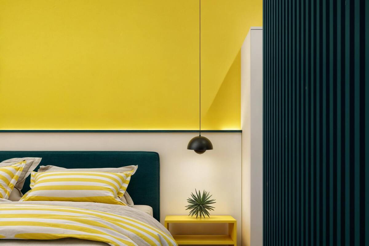 Ein modernes Schlafzimmer mit Bett, Nachttisch und einer Topfpflanze.