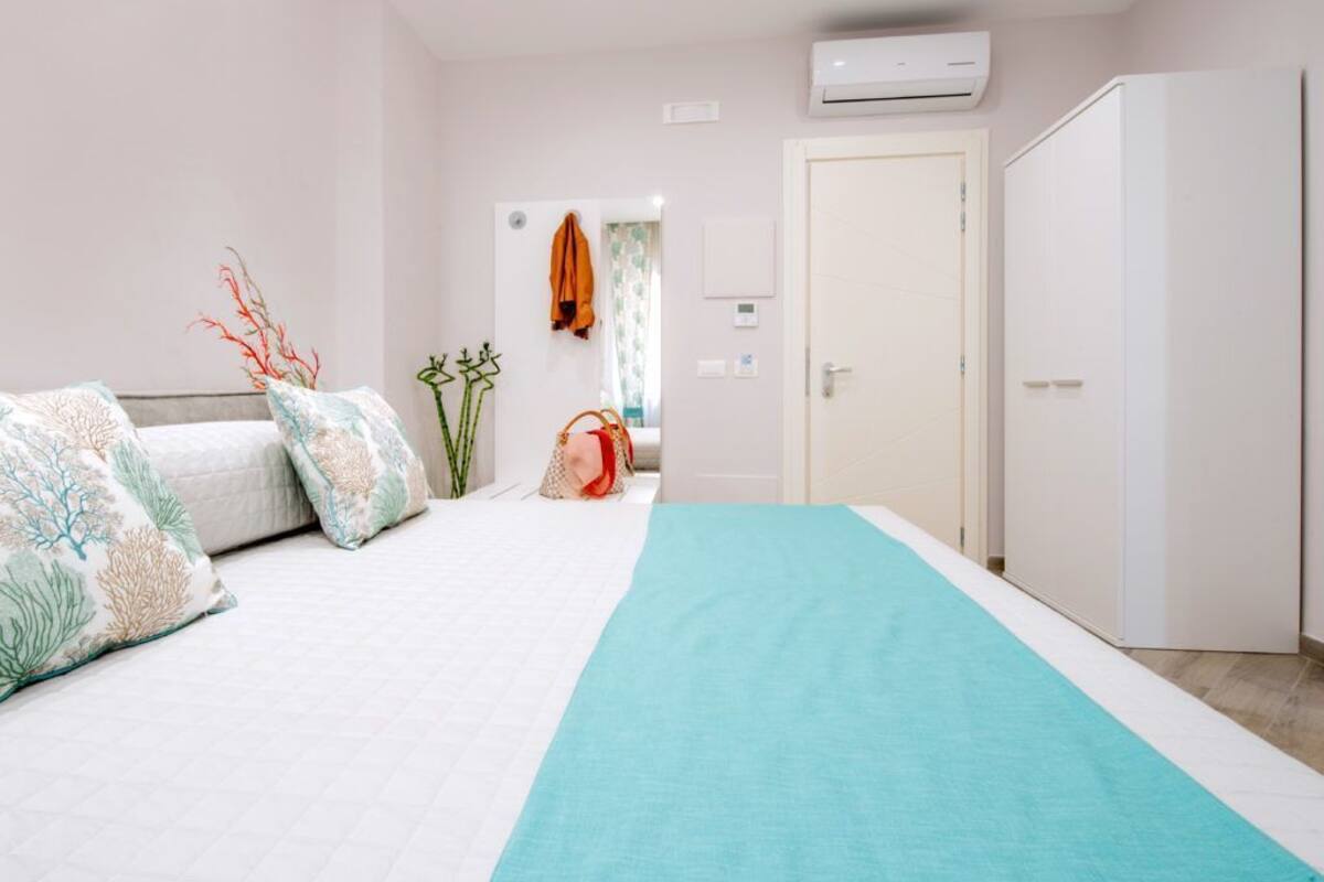 Ein Schlafzimmer mit Bett, Kleiderschrank, einer Tür und einer Wand-Klimaanlage.