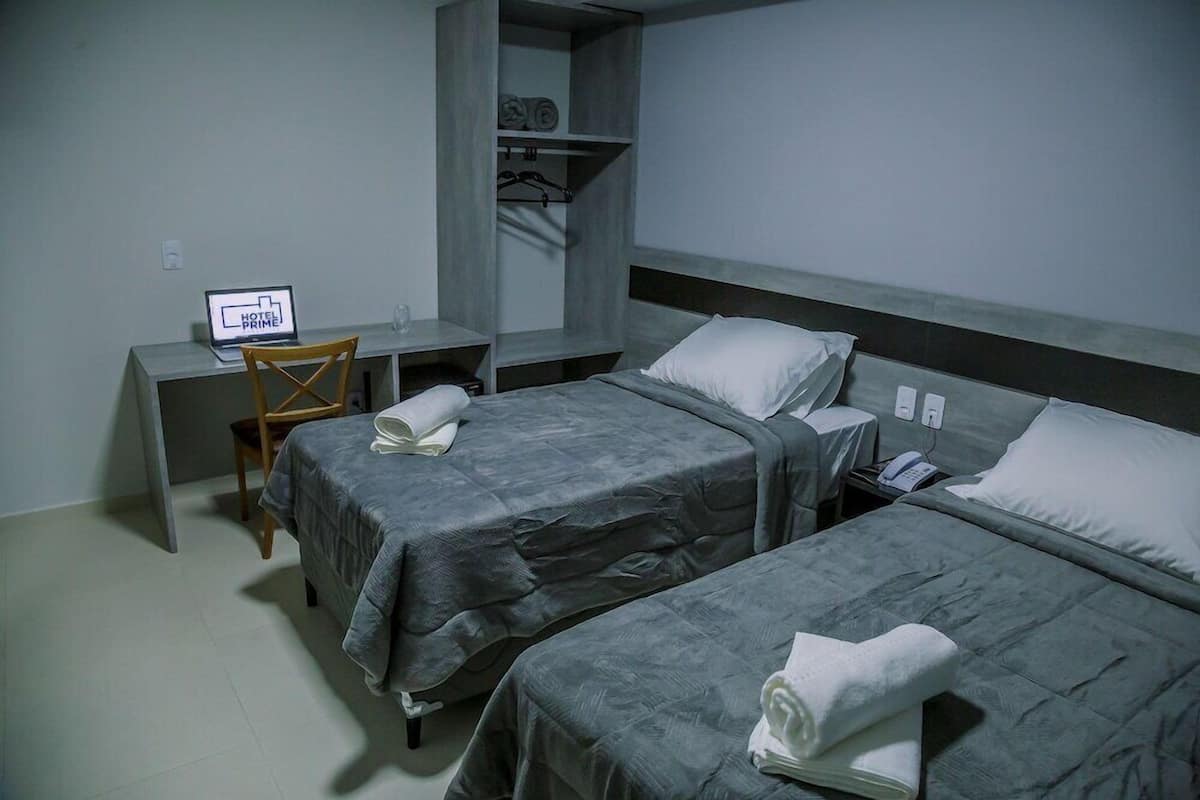 Una habitación de hotel con dos camas, un escritorio y una silla.