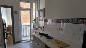 Una cucina moderna con piano cottura a gas, lavello e backsplash in piastrelle bianche.