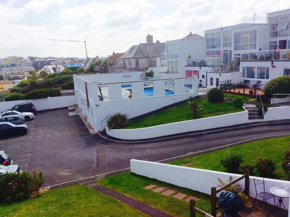 A residential building with a pool, a garage, and a street view.