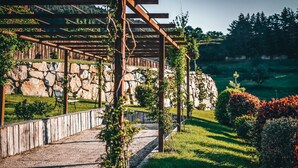 A covered outdoor seating area with stone walls and a gravel path. - gite / house ardéchoise of character with swimming pool (Labatie-D'andaure)