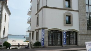 A building with 'AGENCE' signs, a beach view, and a sign for 'GALICIA'. - Breathtaking sea view  (Quiberon)