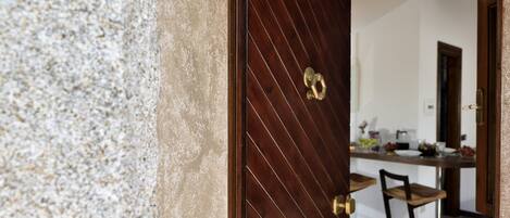 A wooden door with the number 11, leading into a room with a kitchen area visible.