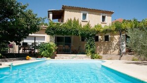 A two-story building with a swimming pool in front. - Spacious, pleasant house in the heart of a Provencal village (Le Pin)