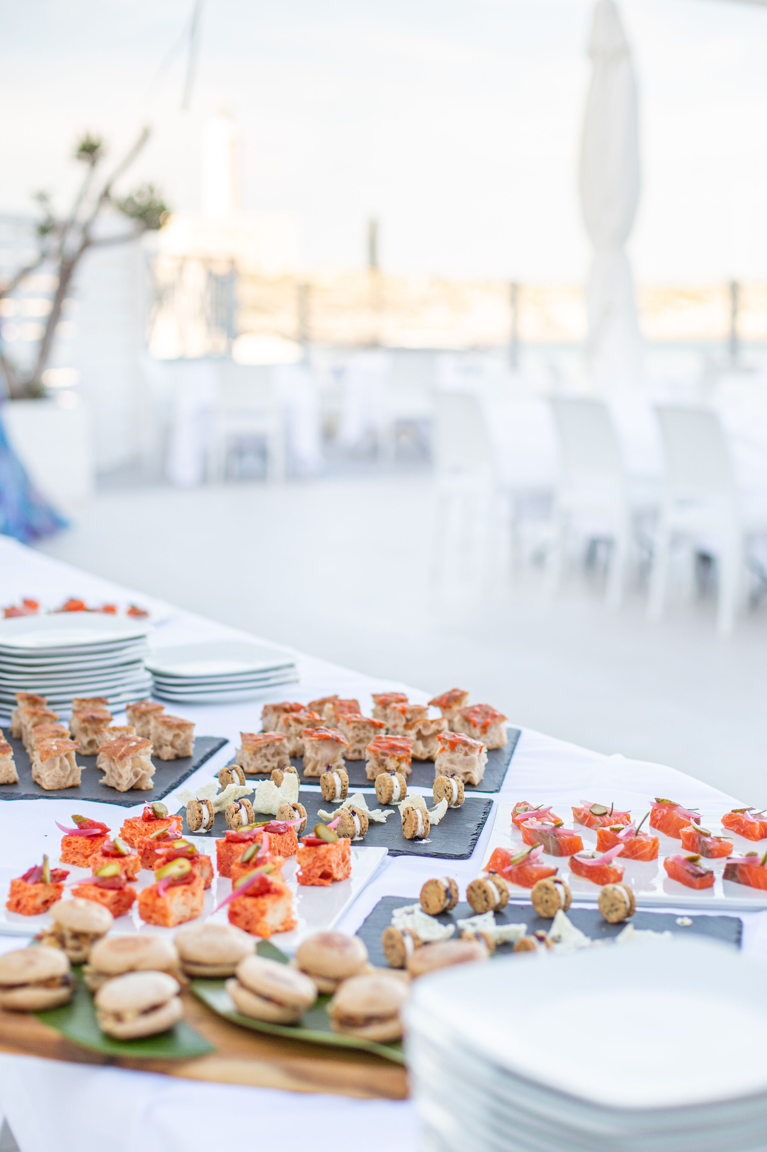 Una mesa de buffet con diversos alimentos y platos apilados.
